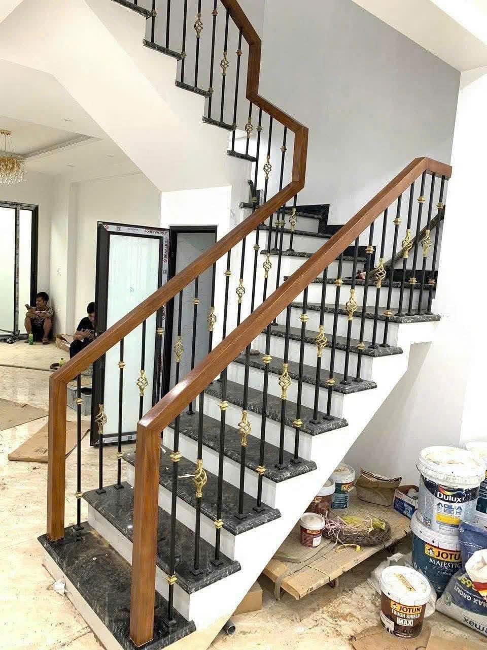 Cầu thang hoa sắt tay vịn gỗ 